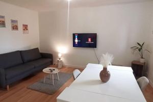 a living room with a couch and a table at Appart cosy proche forêt in Vert-Saint-Denis