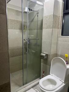 a bathroom with a toilet and a glass shower at Rosette Haven 2 in Nairobi