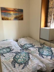 Una cama con dos almohadas encima en un dormitorio. en ゲストハウスブルーオーシャン那覇, en Naha 21 fotos más