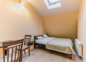 a bedroom with a bed and a desk and a chair at Gar'is Hostel Lviv in Lviv
