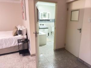 a bedroom with a bed and a bathroom with a sink at Hilltop Compound in Maseru +33 photos