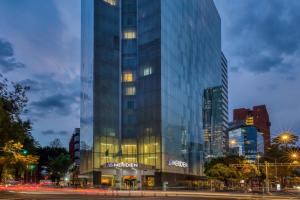 a tall glass building in a city at night at Le Méridien Mexico City Reforma in Mexico City