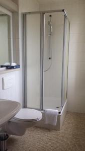 La salle de bains est pourvue d'une douche, de toilettes et d'un lavabo. dans l'établissement Hotel Hasen Kaufbeuren Allgäu, à Kaufbeuren