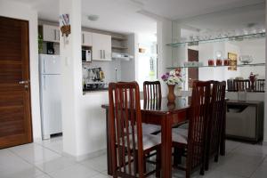 cocina con mesa, sillas y nevera en Apartamento Green Park, en João Pessoa