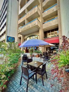 a table and chairs with an umbrella in front of a building at Midtown Hotel & Suites in Beirut