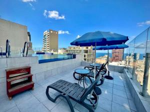 a patio with two chairs and a table and an umbrella at Midtown Hotel & Suites in Beirut
