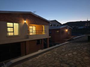 a view of a building with a balcony at dusk at Hilltop Compound in Maseru