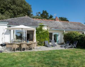 a patio with a table and chairs and an umbrella at Carn Du 1 in Padstow