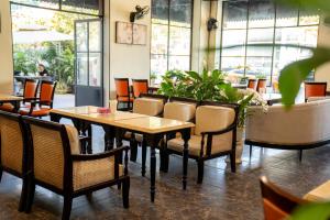 a dining room with tables and chairs and plants at Khách sạn Pha Đin in Diện Biên Phủ