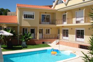 a villa with a swimming pool in front of a house at Hotel Rural Solar Das Freiras in Figueiró dos Vinhos