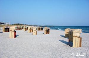 a row of benches on a beach near the water at 29 Ferienwohnung Stranddistel App. 56-409 in Burg auf Fehmarn