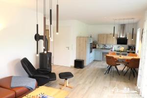 a living room and kitchen with a table and chairs at 25 Ferienwohnung Mummengarten mit Wallbox in Landkirchen