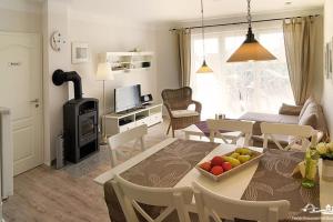 cocina y sala de estar con una mesa con fruta. en 27 Ferienwohnung an der Reiterkoppel 49a EG, en Burg auf Fehmarn