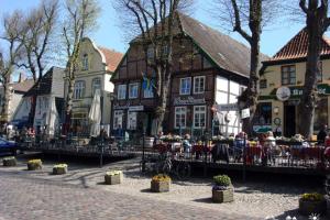 a group of people sitting at tables in front of a building at 22 Ferienwohnung Fuhr An der Reiterkoppel 1 EG in Burg auf Fehmarn