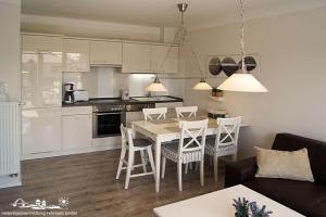 a kitchen and dining room with a table and chairs at 28 Fehmarn An der Reiterkoppel 49b EG in Burg auf Fehmarn