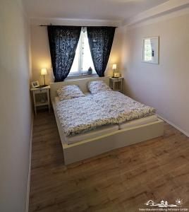 Un dormitorio con una cama con dos almohadas y una ventana. en 28 Fehmarn An der Reiterkoppel 49b EG, en Burg auf Fehmarn