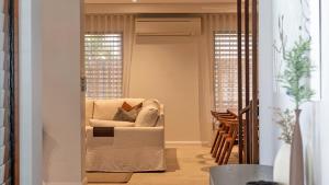 a living room with a chair and two windows at Villa 1 Chez Willow Port Douglas in Port Douglas