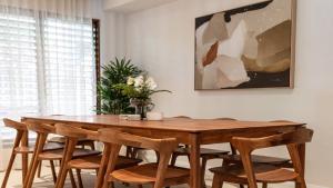 a dining room table with chairs and a vase of flowers at Villa 1 Chez Willow Port Douglas in Port Douglas +15 photos