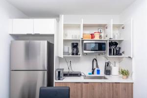 a kitchen with a refrigerator and a sink at Stylish Studio Miami Suite Oasis Near Calle Ocho & Brickell in Miami