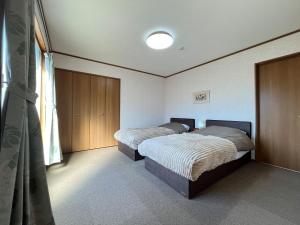 a bedroom with two beds and a window at New Hoshiba in Nozawa Onsen