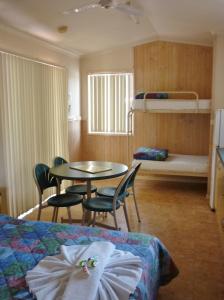 a hotel room with a bed and a table and chairs at Roma Big Rig Tourist Park in Roma