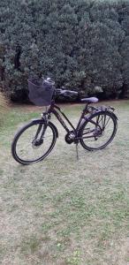 a bike with a basket parked in the grass at Vacation home Ivana in Vukovar