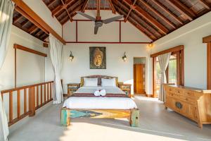 Un dormitorio con una cama y un techo de madera. en Villa Shanti Ceningan, en Nusa Lembongan