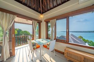 Una habitación con balcón con mesa y sillas. en Villa Shanti Ceningan, en Nusa Lembongan