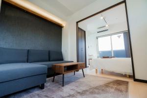 a living room with a blue couch and a bed at Apartment Hotel MODISH Gion in Giommachi