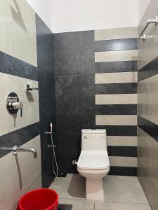 a bathroom with a toilet and a black and white striped wall at Green valley home stay in Thekkady +16 photos