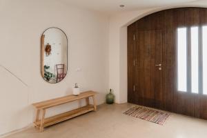 ein Zimmer mit einer Holztür, einem Tisch und einem Spiegel in der Unterkunft L'Olivera in Rupiá