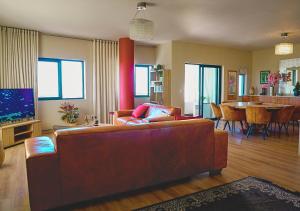 a living room with a couch and a dining room at Knightsbridge Luxury Escape in Cape Town