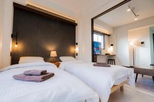 two beds in a bedroom with a large mirror at Apartment Hotel MODISH Gion in Giommachi