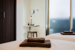 a hotel room with two beds with towels on them at Apartment Hotel MODISH Gion in Giommachi +101 photos