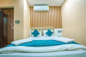 a bedroom with a large bed with blue pillows at Silver Star Residency in Bhubaneshwar