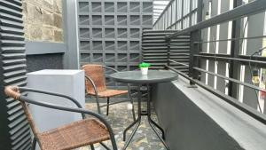 a patio with two chairs and a table on a balcony at Casaluna Bed & Breakfast By Avalon in Purwokerto