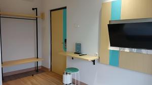 a room with a flat screen tv on a wall at Casaluna Bed & Breakfast By Avalon in Purwokerto