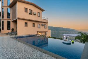 a house with a swimming pool next to a building at Thalaiva Villa by Hillstayion in Panchgani