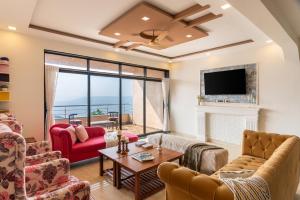 a living room with a fireplace and a tv at Thalaiva Villa by Hillstayion in Panchgani