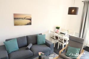 sala de estar con sofá y mesa de comedor en 38 Weiße Villa am Schwanenteich EG links, en Burg auf Fehmarn 10 fotos más