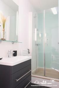 un baño con lavabo y ducha en 38 Weiße Villa am Schwanenteich EG links, en Burg auf Fehmarn