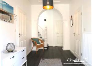 pasillo blanco con silla y cómoda en 38 Weiße Villa am Schwanenteich EG links, en Burg auf Fehmarn