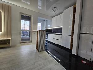 Una cocina con gabinetes blancos y una ventana grande. en Aparthotel Militari, en Roşu 5 fotos más