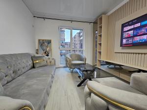 Una sala de estar con un sofá y un televisor. en Aparthotel Militari, en Roşu
