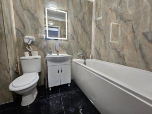 Un baño con inodoro, bañera y lavabo. en Aparthotel Militari, en Roşu