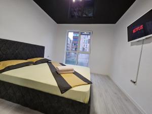 1 dormitorio con 1 cama con cabecero negro y ventana en Aparthotel Militari, en Roşu