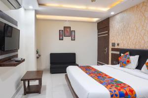 a hotel room with a bed and a chair at FabHotel Jalsa DLX in Bhopal +25 photos