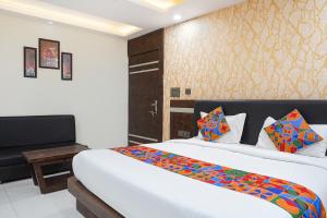 a bedroom with a large white bed in a room at FabHotel Jalsa DLX in Bhopal