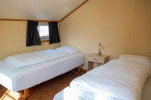 RørvikにあるRorbuer i sentrumの窓のある小さな部屋にベッドが2つある