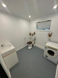 a white bathroom with a sink and a toilet at The Village Eco Stay Byron Bay in Byron Bay